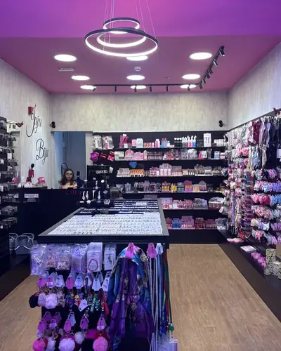 A loja por dentro, com o teto rosa e o lustre de anéis de luz